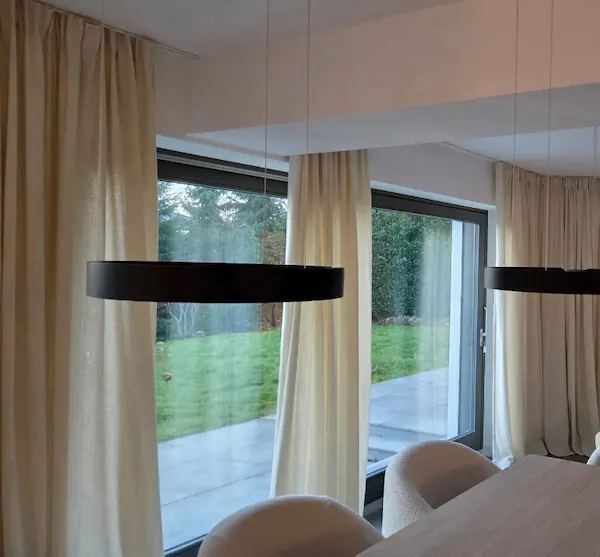 Bild von montierten weißen Vorhängen mittels Schienensystem in einem Wohnzimmer